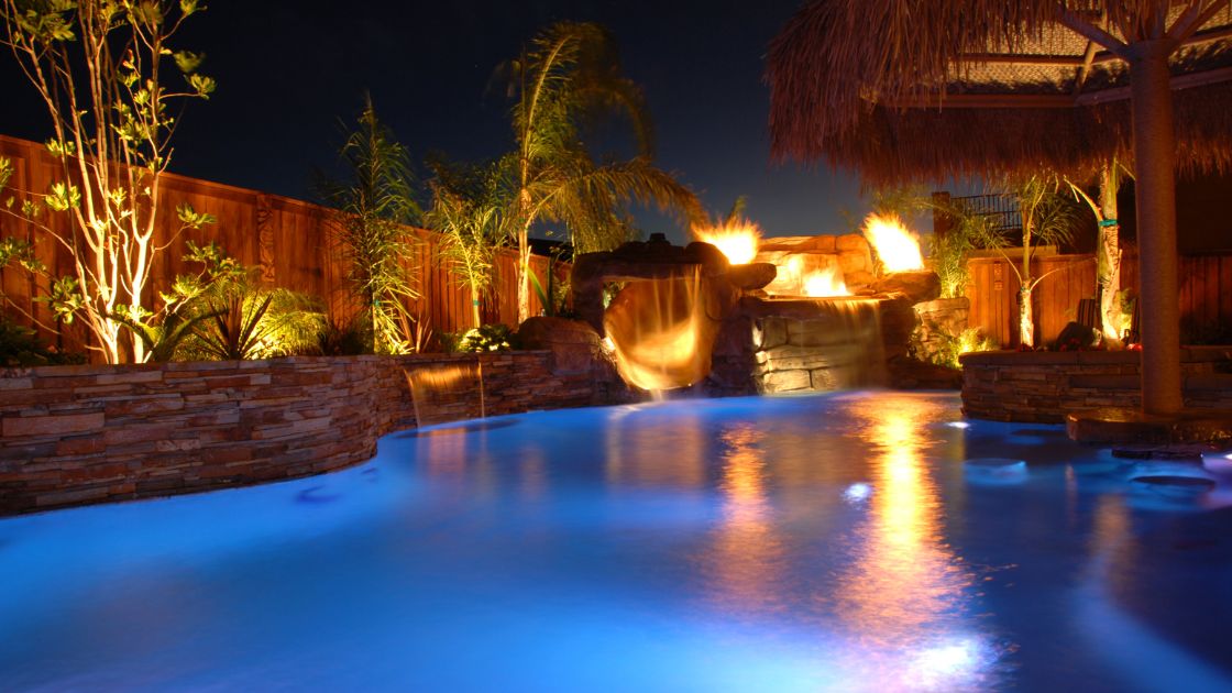 a well-lit pool with a water fountain and shading upgrades